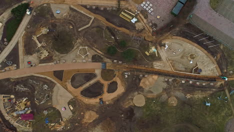 Aerial-birdseye-view-over-a-large-construction-site-with-view-of-construction-vehicles-and-construction-machinery-in-latvia,-riga-in-beautiful-latvia-on-a-warm-summer-day