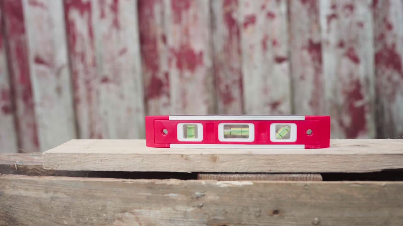 la mano coloca la barra de nivel en la tabla de madera. primer plano