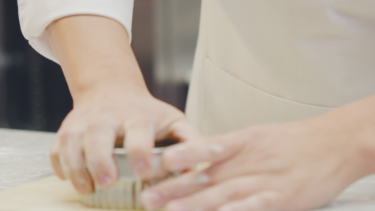 Chef's hands shaping, cutting the dough and filling the Ravioli with artisanal technique in a professional kitchen