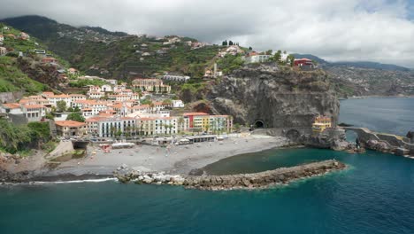 Secluded-little-beach-protected-by-breakwater-with-Mediterranean-style-buildings