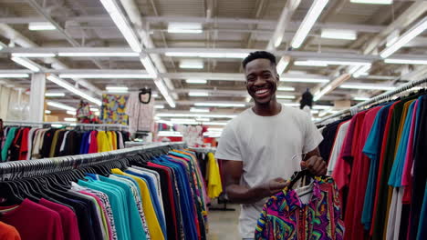 man browsing colorful clothes in a store