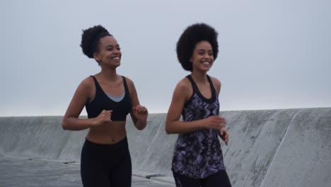 two mixed race women running on docks