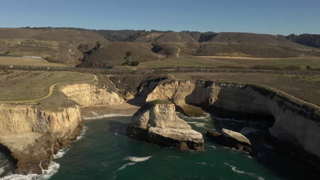 Slow-drone-orbit-around-Shark-Fin-Cove-in-Davenport,-California