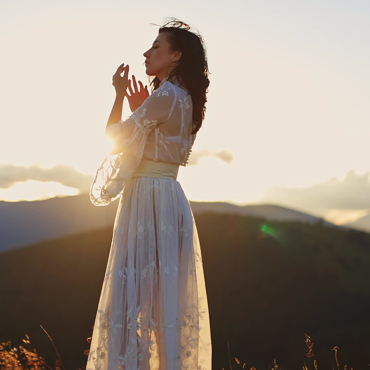 Young beautiful lady in dress walking in mountains. Outdoor happy woman dancing on the nature