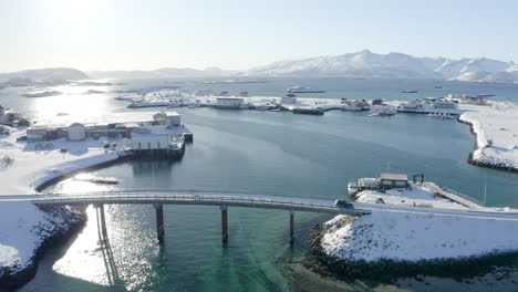 aerial view of beautiful arctic winter scenery with car passing bridge in sommarøy, norway