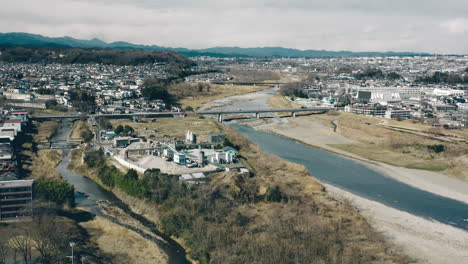 Centro-De-Reciclaje-Entre-Tama-Y-El-Río-Hirai-Con-Puente-Tama-Y-Nagata-En-La-Distancia-En-Fussa,-Tokio,-Japón