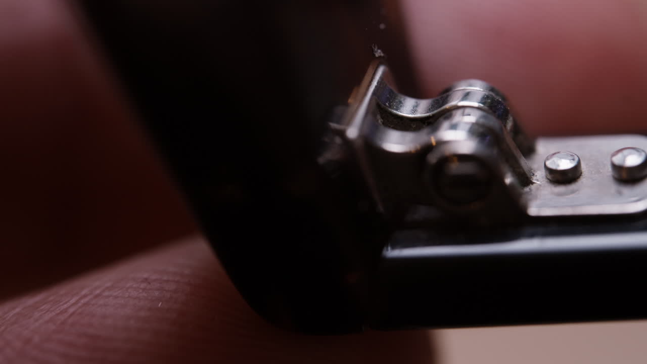Extreme macro close-up of an old eyeglasses hinge being opened and closed by hand. Fine metal details, wear and movement clearly visible. Highly detailed and satisfying technical footage