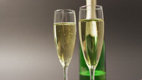 Video-of-champagne-in-glasses-and-bottle-on-grey-background