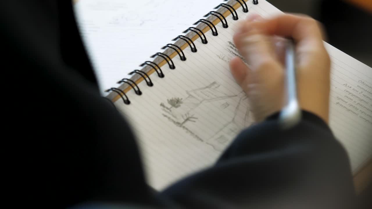 노트북 에 집 의 디자인 을 스케치 하는 사람