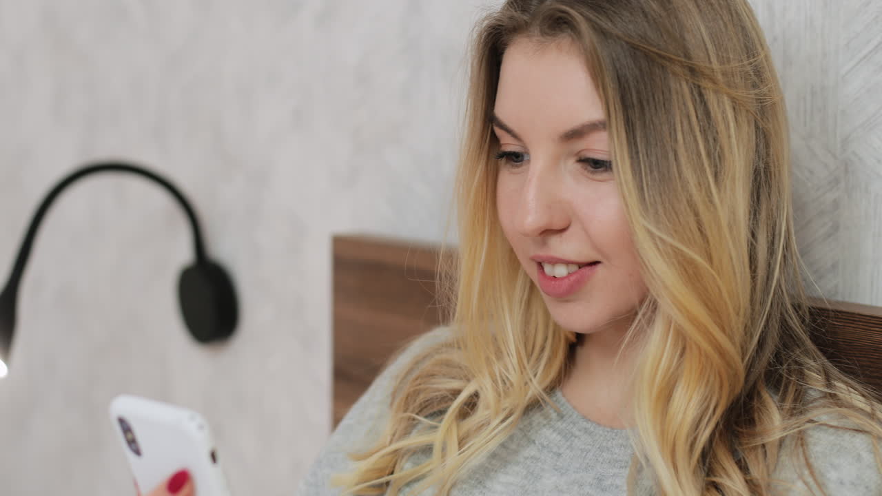 mujer usando teléfono inteligente en la cama