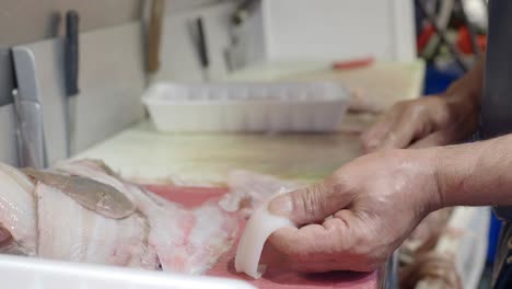 fishmonger preparing fresh fish at a market