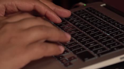 Hands typing and clicking on a laptop keyboard