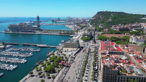 aerial view over square portal de la pau, and port vell marina and columbus monument during a sunny day in barcelona, catalonia, spain
