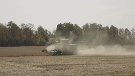 polvo nublado de una cosechadora en funcionamiento en un gran campo de trigo