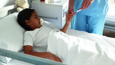 female doctor checking a sugar level of sick girl