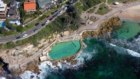 bronte beach in new south wales australia - empty bronte baths with crashing waves on sea walls during covid19 pandemic