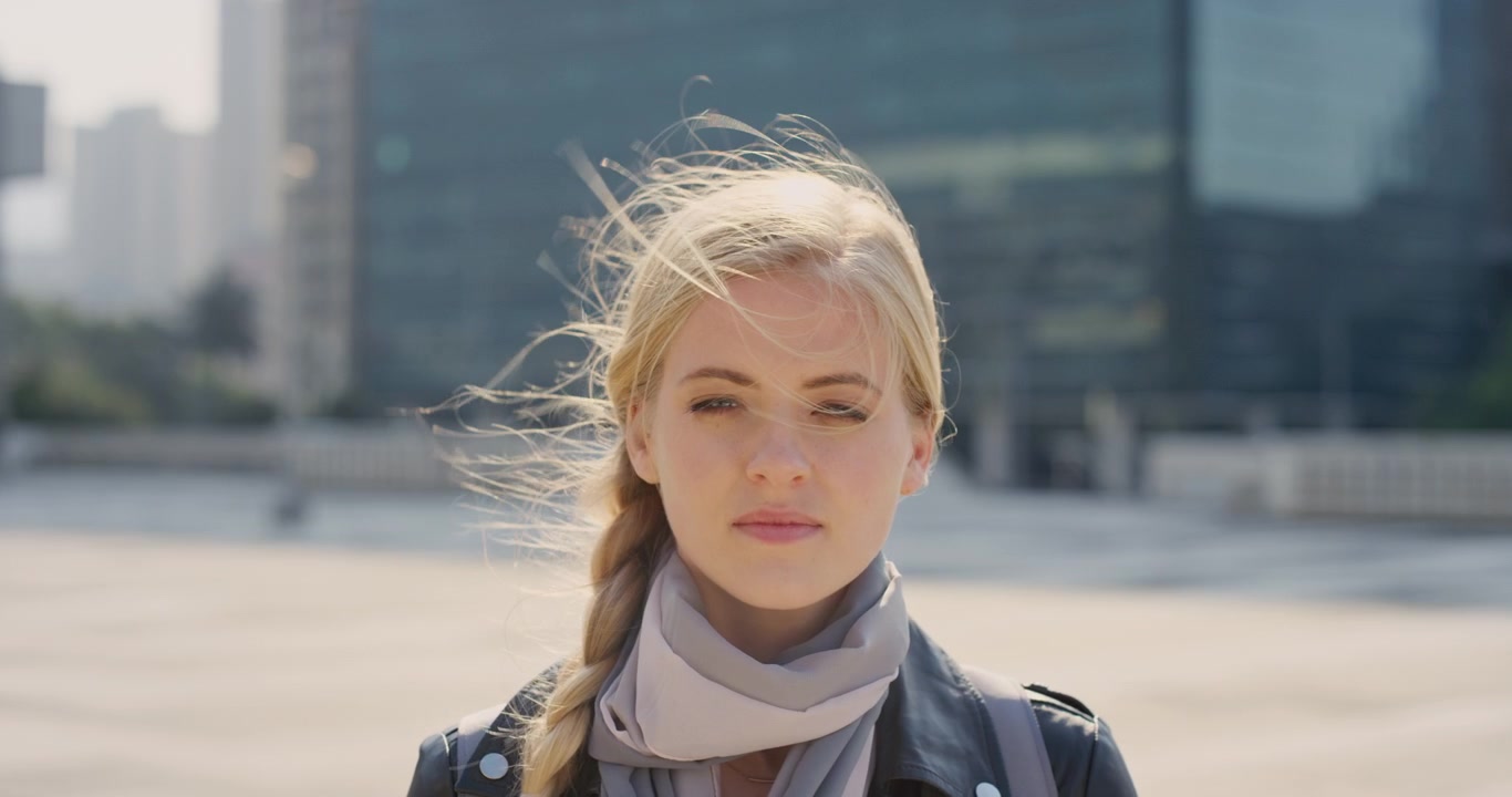 Young Blonde Woman Adjusting Her Hair Outdoors in the City