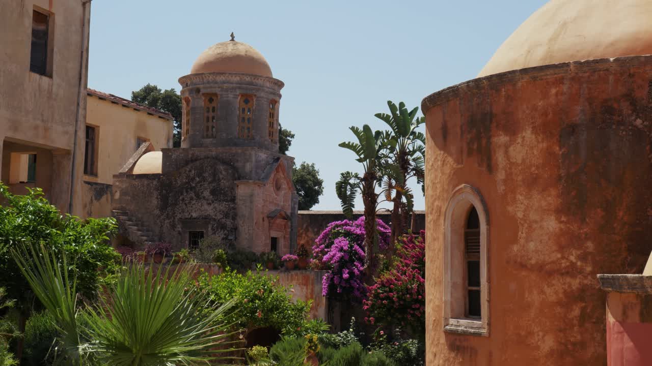 edificios griegos mediterráneos medievales con pintorescas plantas y flores de colores en el monasterio ortodoxo griego agia triada santísima trinidad, creta grecia