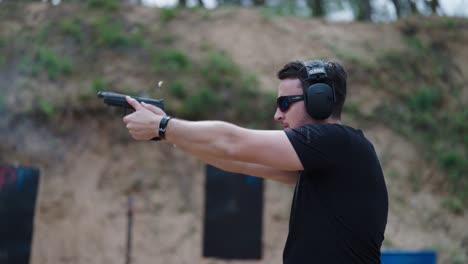 Person-at-shooting-range-fire-bullets-from-handgun,-empty-casings-fly,-Czechia