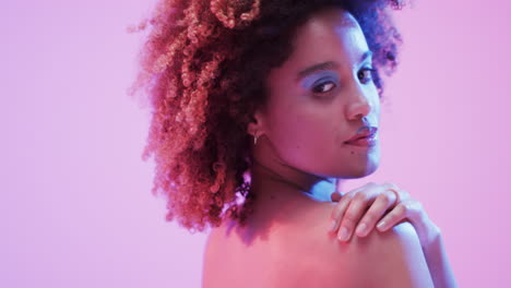 mujer biracial con cabello oscuro en luz azul y rosa, cámara lenta