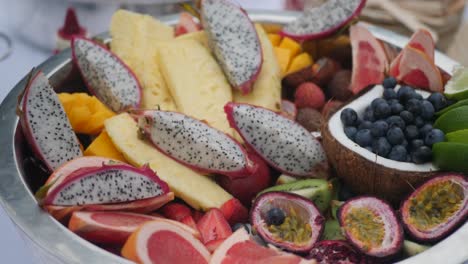 Closeup-of-a-tropical-multi-fruits-bowl-with-passion-fruits,-dragon-fruits,-coconut,-blueberries