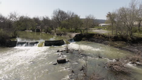 Slow-motion-rotating-shot-of-a-small-dam-with-an-abandoned-pump-station-at-white-river