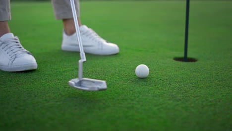 golfer legs hitting ball on green golf course. sport player teeing score outside