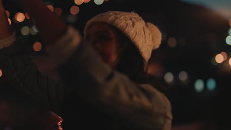 young-woman-holding-sparklers-celebrating-new-years-eve-on-rooftop-at-sunset-having-fun-with-friends-enjoying-holiday-party-celebration