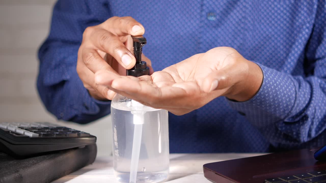 persona que aplica desinfectante para las manos