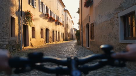 cycling through a charming sunlit cobblestone street in an old european town