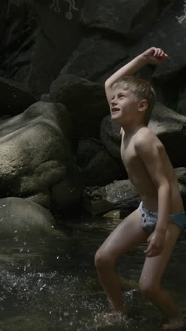 boy playing in a creek