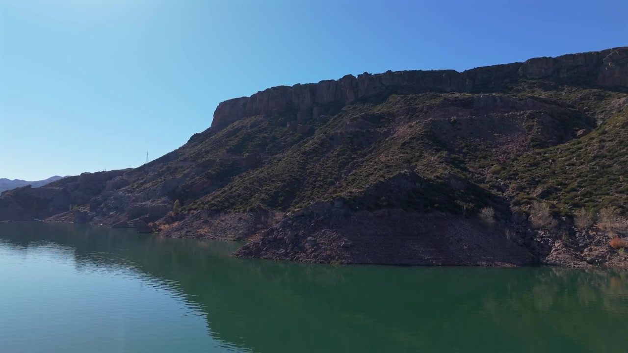 Scarpate rocciose che scendono nel bacino idrico di Valle Grande all'interno del Cañón del Atuel vicino a San Rafael, Mendoza, Argentina, con terreno andino arido modellato da sollevamento tettonico ed erosione, parallasse da drone