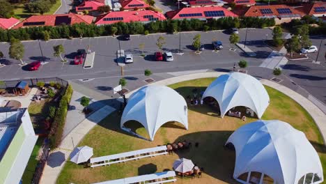 orbit view over white dome tents and picnic benches setup ready for outdoor event