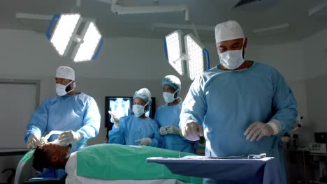 Portrait-of-biracial-male-surgeon-preparing-surgical-instruments-in-operating-theatre,-slow-motion