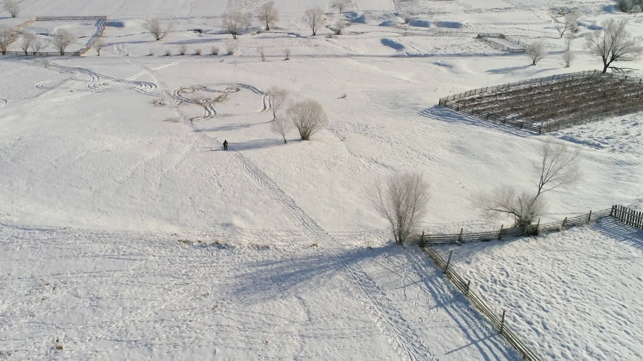 Tracking with a drone of a skier descending a narrow road.