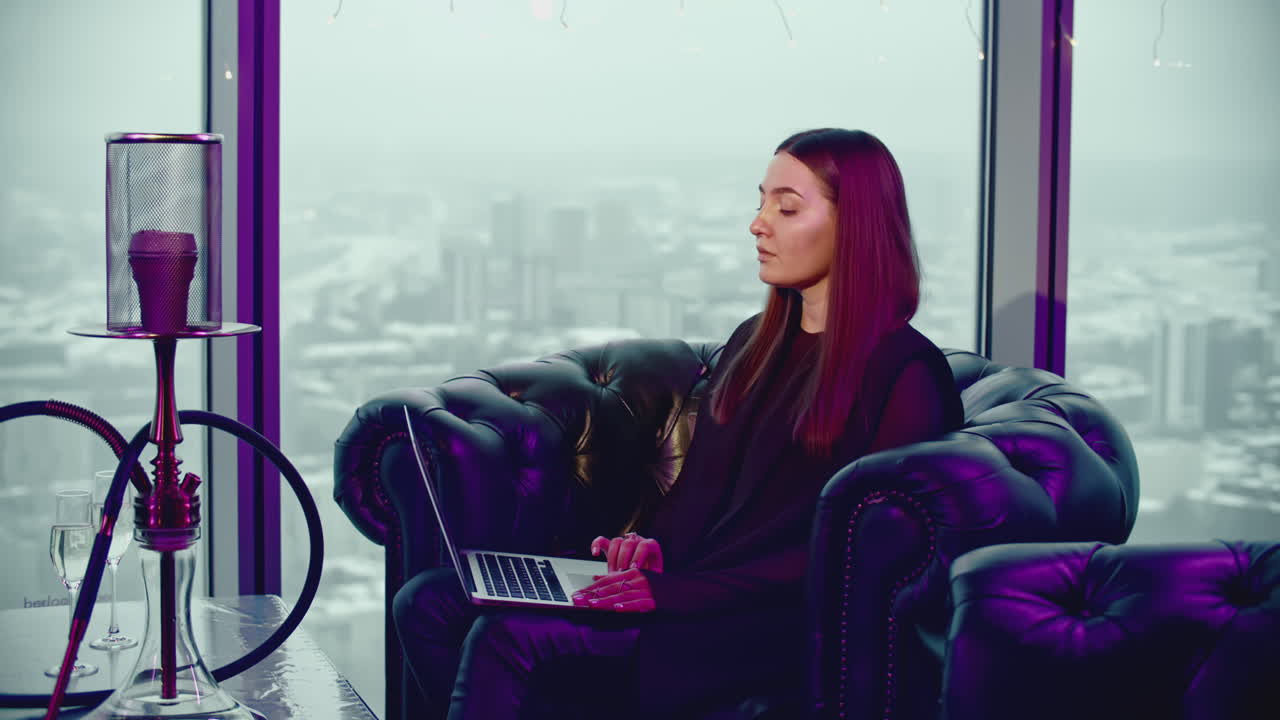 mujer trabajando en una computadora portátil en un café de gran altura con una vista