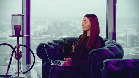 woman working on laptop in a high-rise cafe with a view