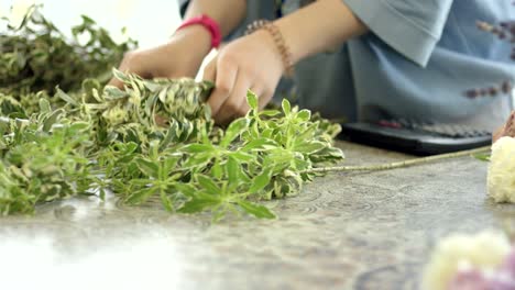 joven florista ensambla un ramo