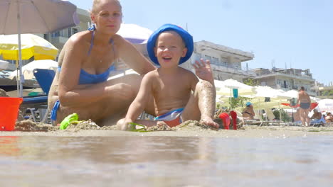 Son-and-mother-waving-hands-at-the-seaside