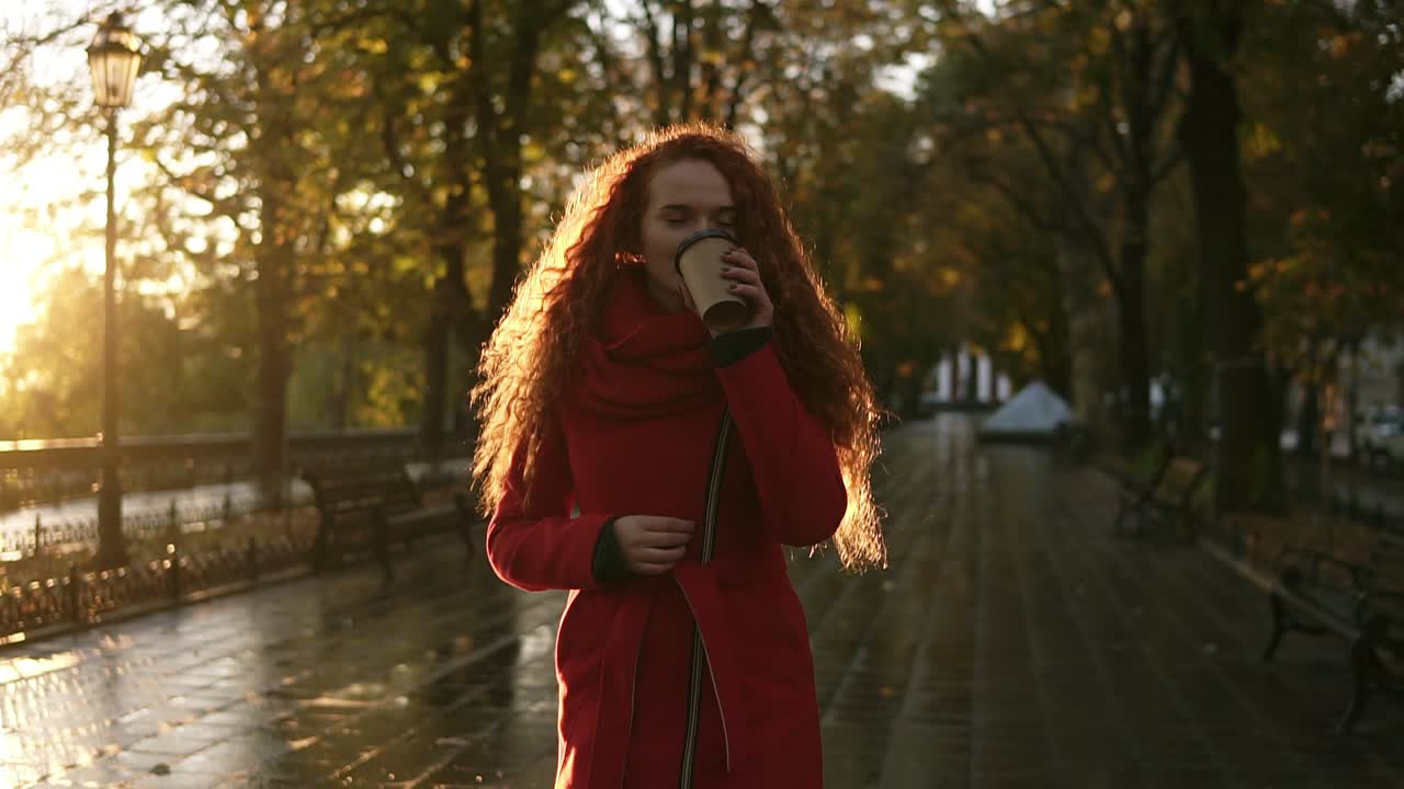 Red haired stunning woman walking on a city park