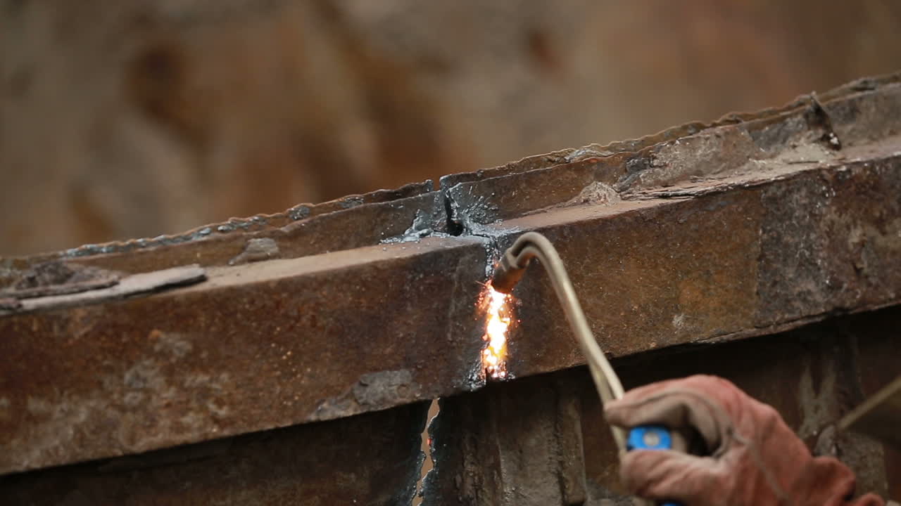 Cutting metal in industry. Worker while doing a welding with arc welder