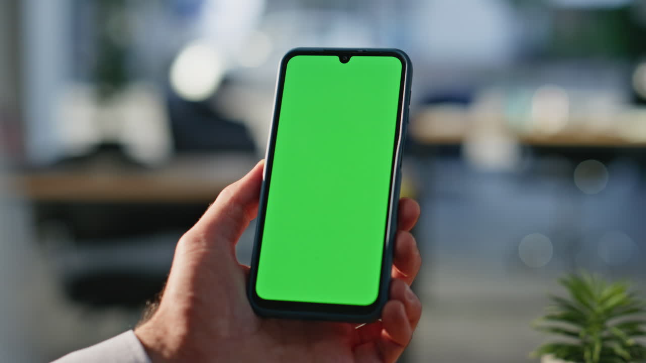 Businessman using chromakey smartphone making online order at workplace closeup