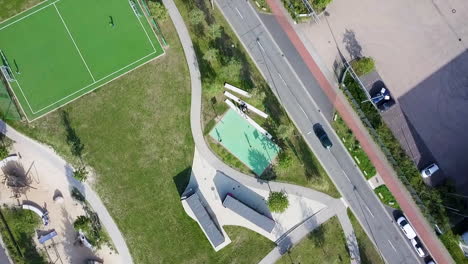 Gente-Jugando-Fútbol-Y-Baloncesto-En-El-Parque-Recreativo-Cerca-De-La-Carretera-De-La-Ciudad