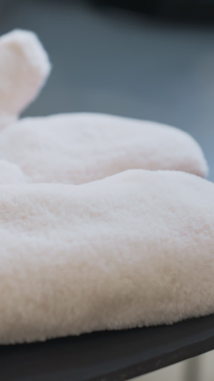 Close-up of a person hand reaching for a cozy knit head warmer resting on soft winter gloves. Warm, comfortable textures with blurred background