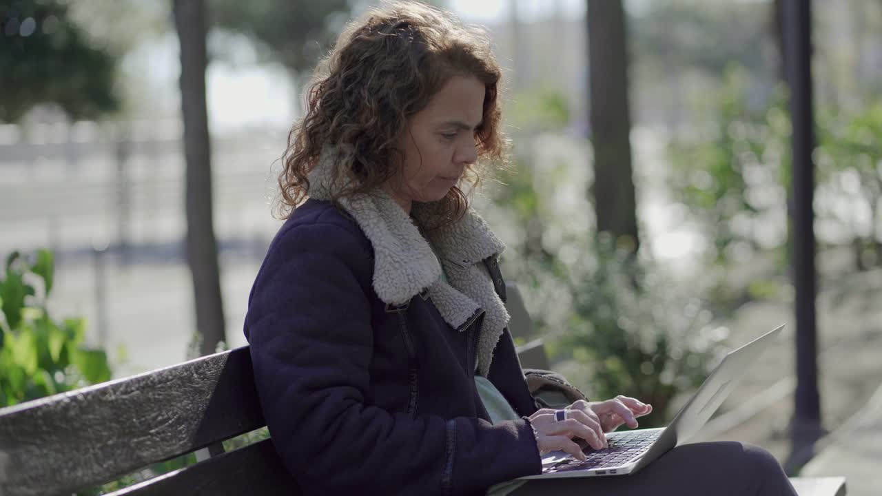 Serious curly female programmer working outdoor