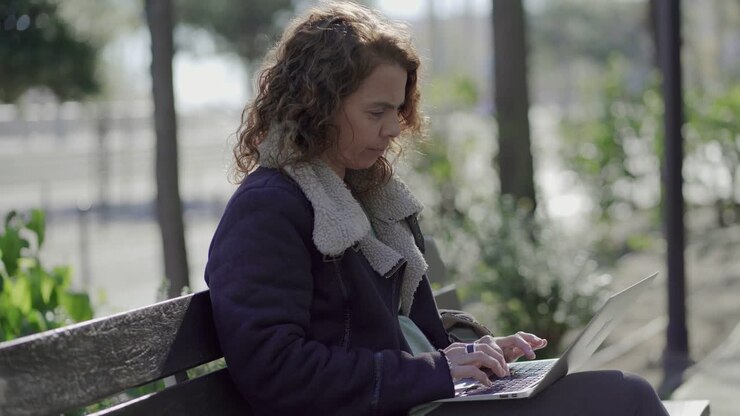 Serious curly female programmer working outdoor