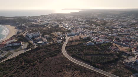 Vista-Aérea-Del-Paisaje-Urbano-De-Sagres-Al-Atardecer-Y-Punta-De-Sagres,-Algarve,-Portugal