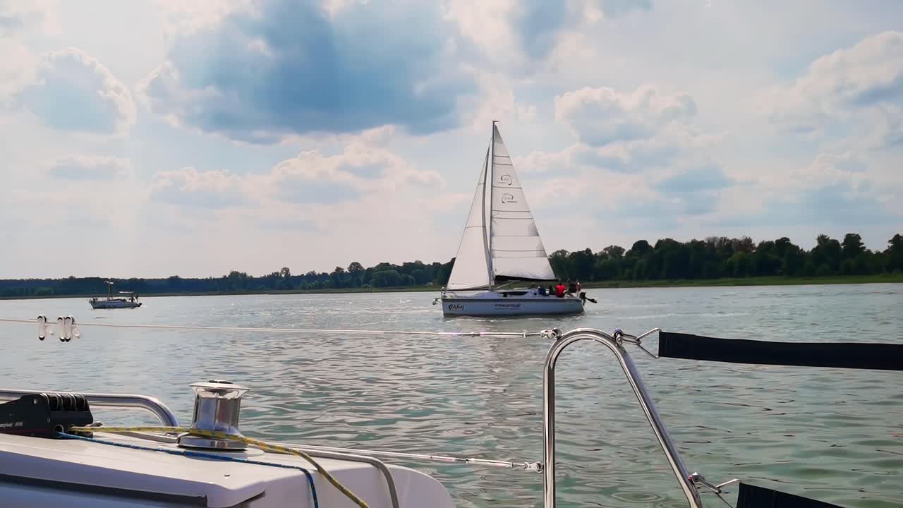 The front bow of a white sailing boat with blue sky and sea background