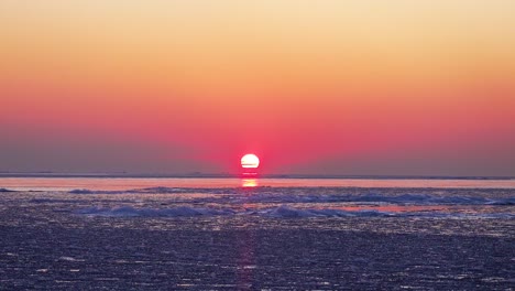 timelapse de la salida del sol sobre el agua congelada en invierno