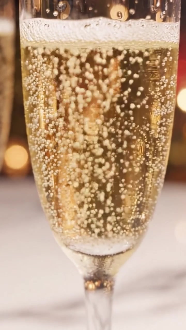 Bevanda frizzante celebrativa in un elegante bicchiere: una vista ravvicinata di bollicine che salgono in una bibita festiva per occasioni speciali.